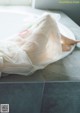 A person laying on a white plate covered in plastic.