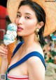 A woman in a straw hat holding an ice cream cone.