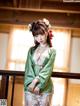 A woman in a green kimono posing for a picture.
