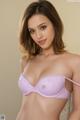 A woman in a purple bra posing for a picture.