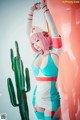 A woman in a nurse outfit posing in front of a cactus.