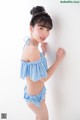 A woman in a blue and white gingham bikini posing for a picture.