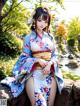 A woman in a blue and white kimono sitting on a rock.