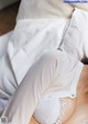 A woman laying on a bed wearing a white bra.