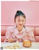 A woman sitting at a table with a plate of food.