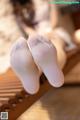 A pair of white socks sitting on top of a wooden bench.